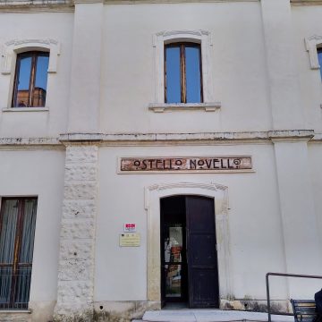 Facciata principale Ostello Novello di Novoli con 3 scalini, portone, insegna con la scritta Ostello Novello e finestra piano superiore